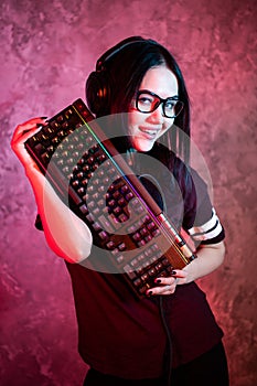 Gamer girl playing with computer at home. Young female posing with computer keyboard.