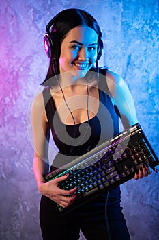 Gamer girl playing with computer at home. Young female posing with computer keyboard.