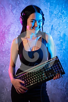 Gamer girl playing with computer at home. Young female posing with computer keyboard.