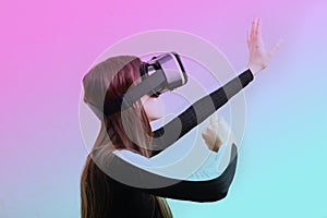 Gamer girl playing video game in glasses helmet virtual reality. visual stimulation of the modern world photo