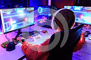 Gamer playing online game on PC in dark room