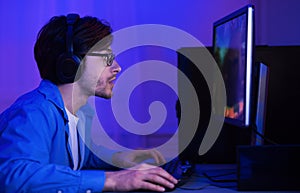 Gamer Taking Part In Online Tournamet Sitting At Computer Indoor