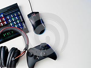 Gamer workspace concept, top view a gaming gear, mouse, keyboard, joystick, headset and mouse pad on white table background.