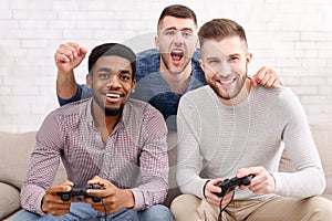 Gamers. Excited men playing video game at home