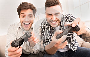 Gamers. Happy guys playing video games at home