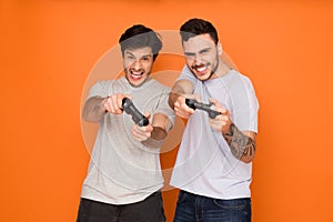 Gamers. Two mates playing video games, orange background