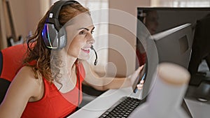 Gaming night unfolds as beautiful caucasian woman streamer syncs smartphone and computer in home office gaming room while smiling, photo