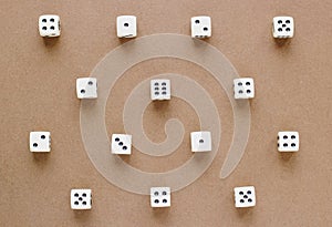 Gaming white dice pattern on brown background in flat lay style.