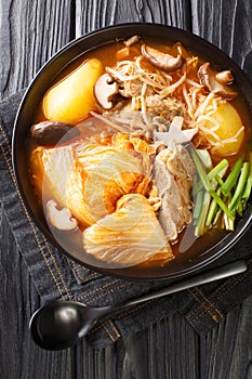 Gamjatang is soup made with pork neck bones and vegetables close up in the plate. Vertical top view