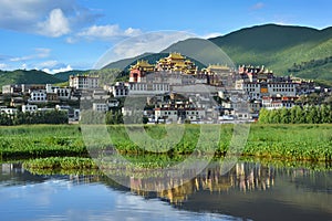 Ganden Songzanlin Complex reflecting in the lake. Shangri-La , China