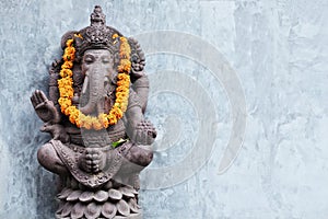 Ganesha sitting in meditating yoga pose in hindu temple