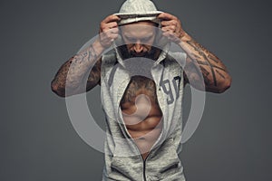 Gangsta tattooed muscular man in a hood.