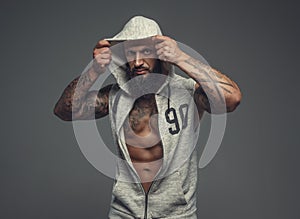 Gangsta tattooed muscular man in a hood.