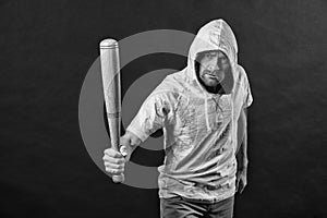 Gangster guy threaten with bat weapon. Man hold baseball bat, aggression. Hooligan wear hood in hoody, fashion. Aggression, anger