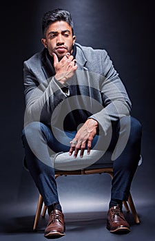 Gangster, portrait and man with fashion in chair on studio, dark background or thinking of power. Serious, person and