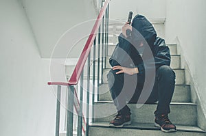 Gangster sitting on stairs, alone with his thoughts and his guns