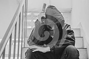 Gangster sitting on stairs, alone with his thoughts and his guns