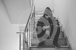 Gangster sitting on stairs, alone with his thoughts and his guns