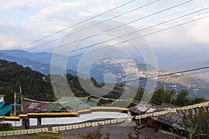 Gangtok mountain village with green trees, blue sky and wire that view form upper level of Rumtek Monastery in winter near Gangtok