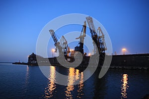 Ganrty cranes in the sea port on the coast of the Azov Sea at susnset
