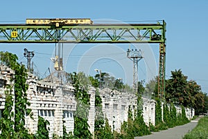 Gantry crane behind a brick fence