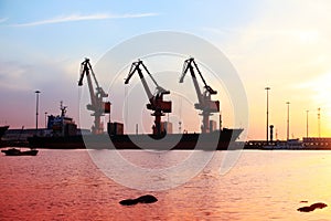 Gantry crane and cargo ship in the evening