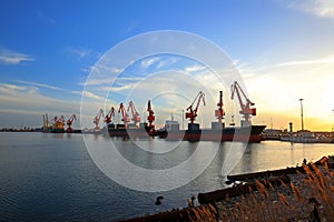 Gantry crane and cargo ship in the evening