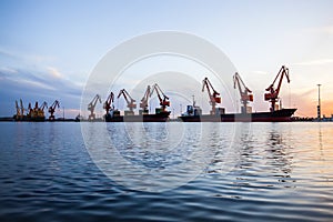 Gantry crane and cargo ship in the evening