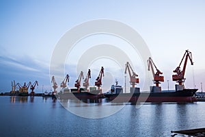 Gantry crane and cargo ship in the evening