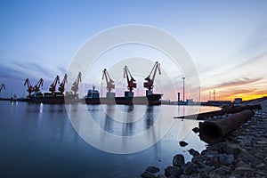 Gantry crane and cargo ship in the evening