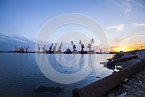 Gantry crane and cargo ship in the evening