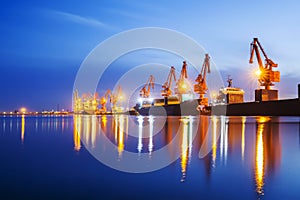 Gantry crane and cargo ship in the evening