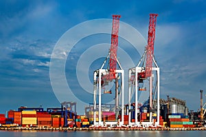 Gantry cranes at shipyard big heavy technique and trucks for logistic goods,container depot. photo