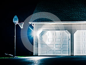 Garage and basketball hoop at night.