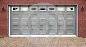 Garage with doors, brick wall and asphalt driveway