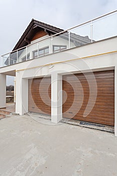 Garage doors in new white house made of blocks.