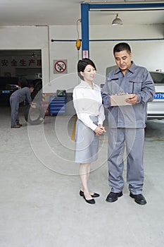 Garage Mechanic Explaining to Customer