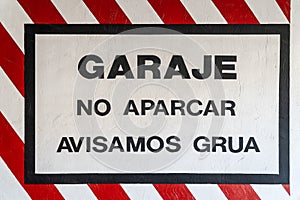 Garage sign, no parking, tow truck warning, painted on the wall at the entrance of a garage