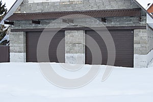 Garage stone with roller shutters in brown color