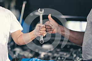 Garage worker mechanic thumb up hand with tool. Finished Work Job Done good fix repair automobile car engine service concept