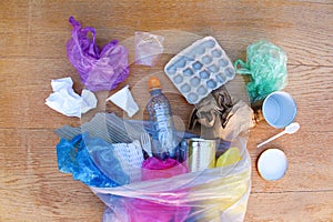Garbage bag with different trash on wooden background. Top view. Flat lay