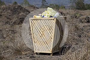 Garbage bamboo bin. Natural wooden waste bin in the park with plastic trashes
