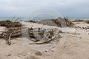 Garbage on the beach. Empty plastic and glass bottles on the sand. Sea shore. Environmental pollution