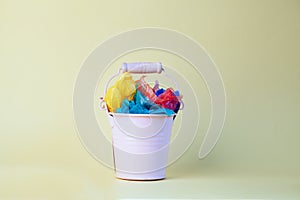 Garbage bin with colorful plastic for recycling isolated on yellow background