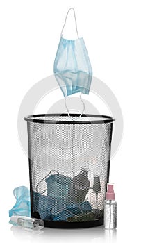 Garbage bin with used personal protective equipment, masks, sanitizers isolated on white