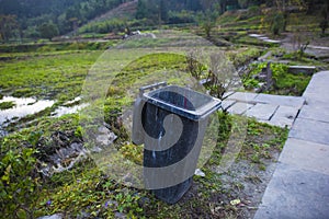 The garbage can on the edge of the field