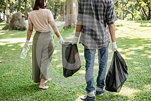 Garbage collection, volunteer team pick up plastic bottles, put garbage in black garbage bags to clean up at parks, avoid