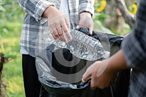 garbage collection, volunteer team pick up plastic bottles, put garbage in black garbage bags to clean up at parks, avoid