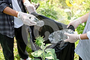 garbage collection, volunteer team pick up plastic bottles, put garbage in black garbage bags to clean up at parks, avoid