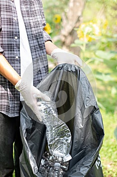 garbage collection, volunteer team pick up plastic bottles, put garbage in black garbage bags to clean up at parks, avoid